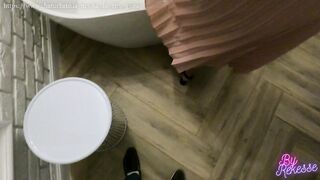 A young brown-haired woman in a long dress sucks off her boyfriend's big dick near the bed and sitting in an empty bathtub