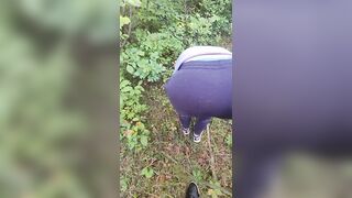 Das Mädchen in einem Sweatshirt und heruntergelassenen Hosen macht einen blowjob und wird im Wald von ihrem Freund gefickt
