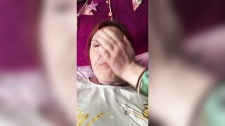 Ein Mann filmt eine rothaarige reife Frau in einem T-Shirt auf einem Smartphone mit einer Nahaufnahme, die mit den Fingern masturbiert, um ihre eingewachsene Muschi zu masturbieren