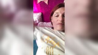 Ein Mann filmt eine rothaarige reife Frau in einem T-Shirt auf einem Smartphone mit einer Nahaufnahme, die mit den Fingern masturbiert, um ihre eingewachsene Muschi zu masturbieren