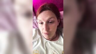 Ein Mann filmt eine rothaarige reife Frau in einem T-Shirt auf einem Smartphone mit einer Nahaufnahme, die mit den Fingern masturbiert, um ihre eingewachsene Muschi zu masturbieren